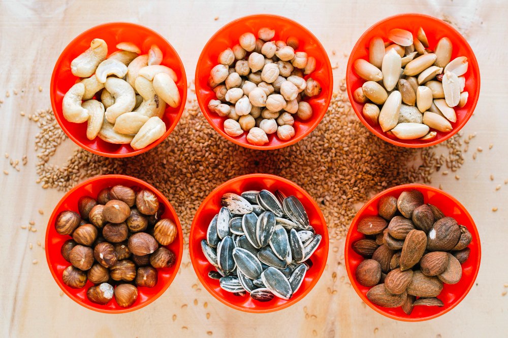 Which Food Is Good for Eyes: Nourish Your Healthy Vision 8 Six bowls of different nuts and seeds, demonstrating foods that are good for eyes, loaded with Vitamin E and omega-3 fatty acids.