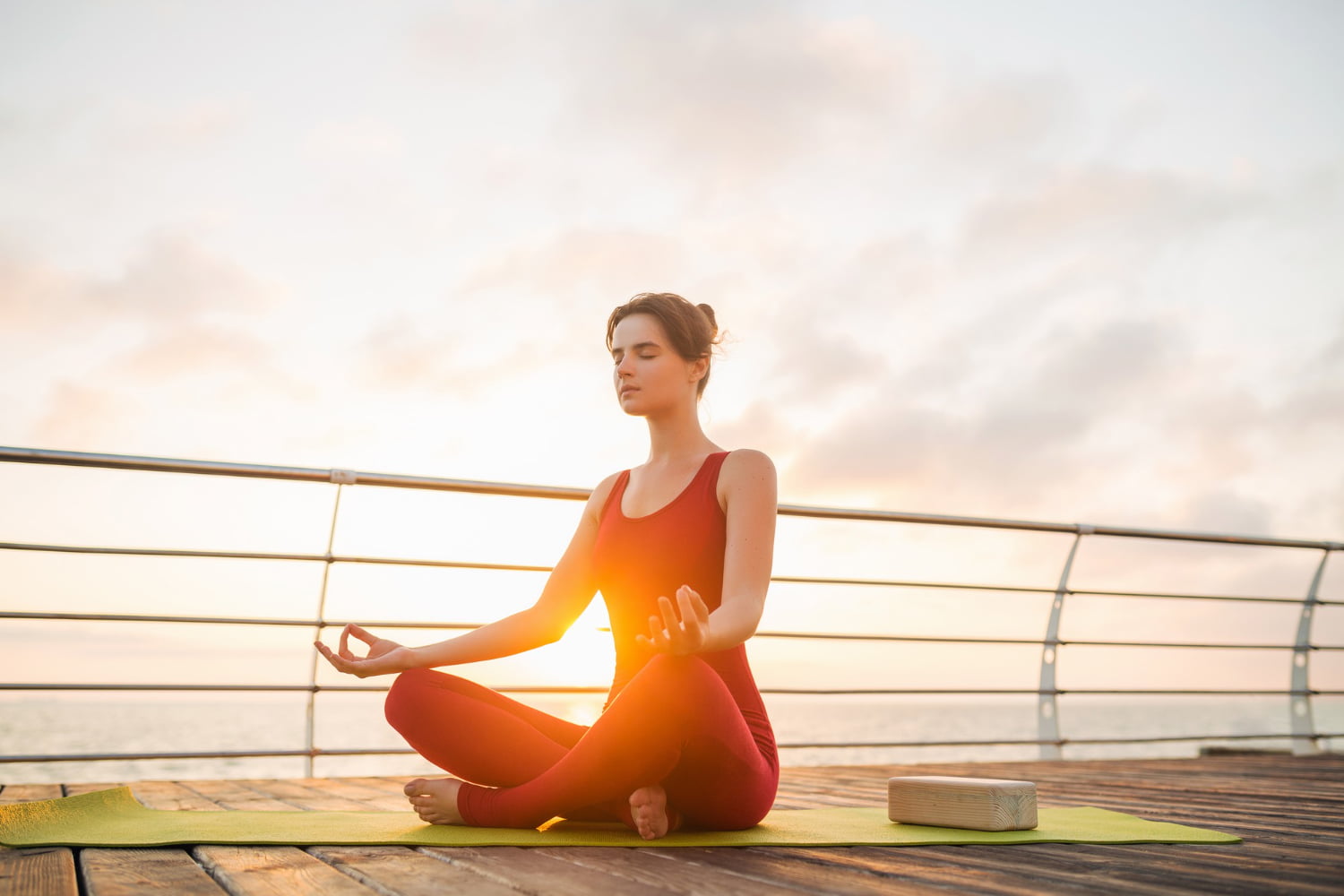 Girl practicing morning meditation, sitting cross-legged with a peaceful expression, surrounded by a tranquil environment for a mindful start to the day.