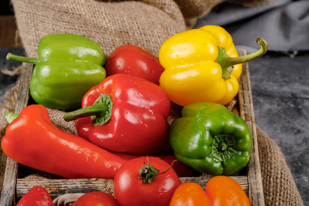 Which Food Is Good for Eyes: Nourish Your Healthy Vision 10 Colorful bell peppers on a cutting board, featuring foods that are good for eyes, high in Vitamin C and beta-carotene.