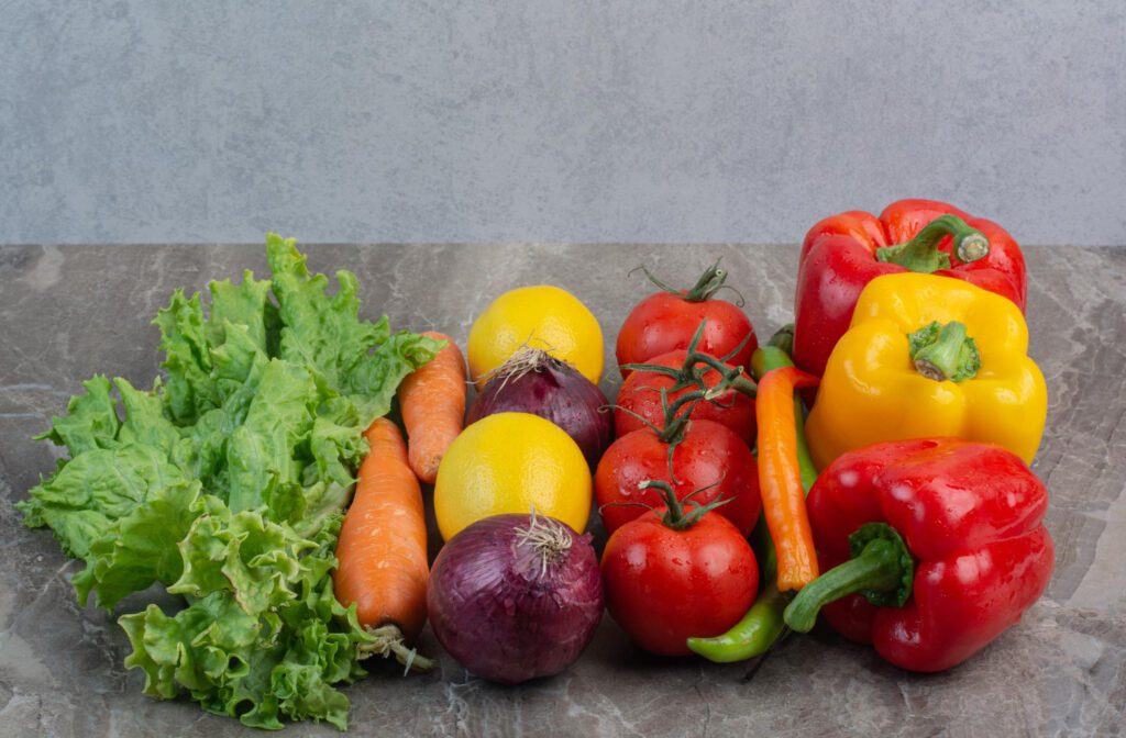 A vibrant selection of seasonal vegetables including carrots, bell peppers, and leafy greens, demonstrating the advantages of seasonal eating to improve nutrition.
