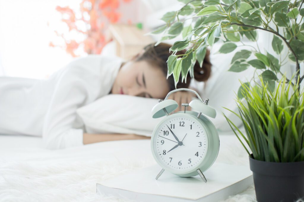Person peacefully sleeping with a watch placed on a nightstand beside them. Get Better Sleep Quality.