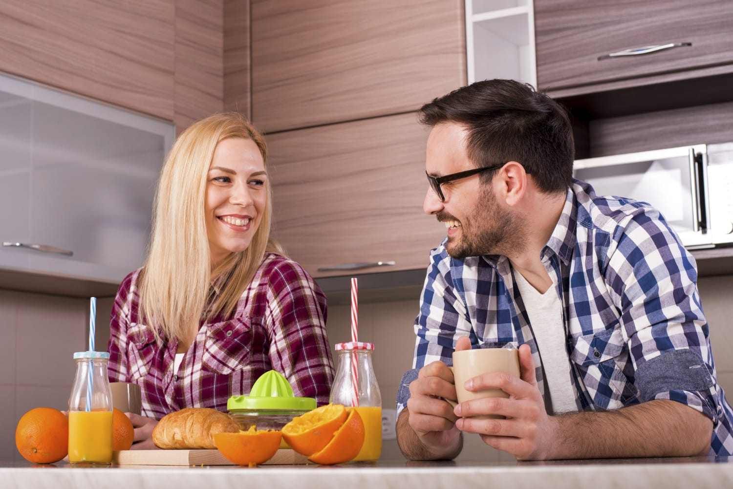 A man and a woman enjoying fruit juices and fresh fruits at a table, highlighting the benefits of daily fruit juice for health.