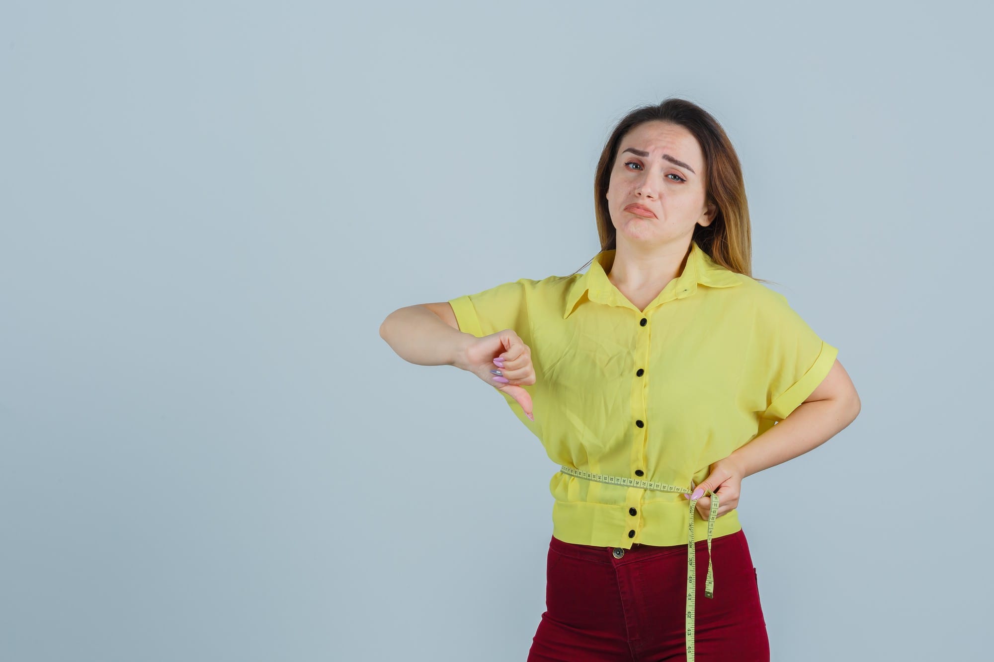 Why Am I Not Gaining Weight Even After Exercising? (10 Reasons & Fixes) 1 Why am I not gaining weight after exercising? Woman measuring her waist with a measuring tape.